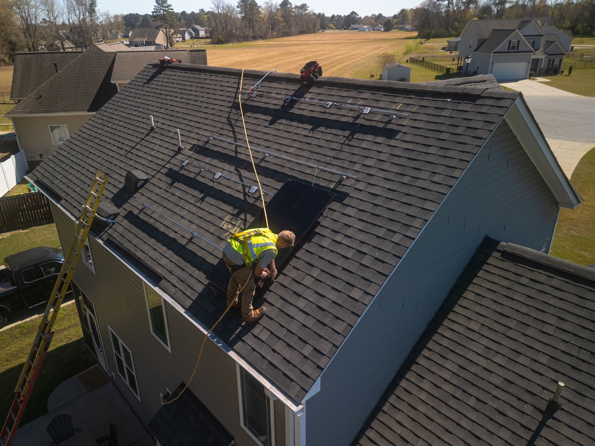 Solar Panel Installer - Safety Harness - Private Home - Sustainable Energy - Mounting Rails - Drone POV